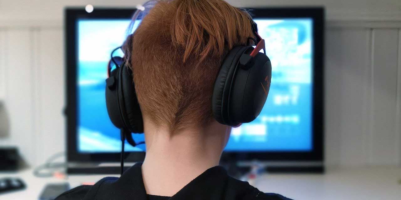 Student with headphones at a computer.