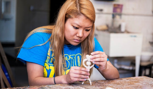 student holding small sculpture