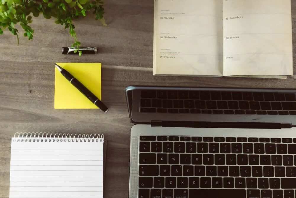 desktop with laptop post its and note pad with pen