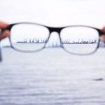 holding up a pair of glasses from a distance focusing on the distance