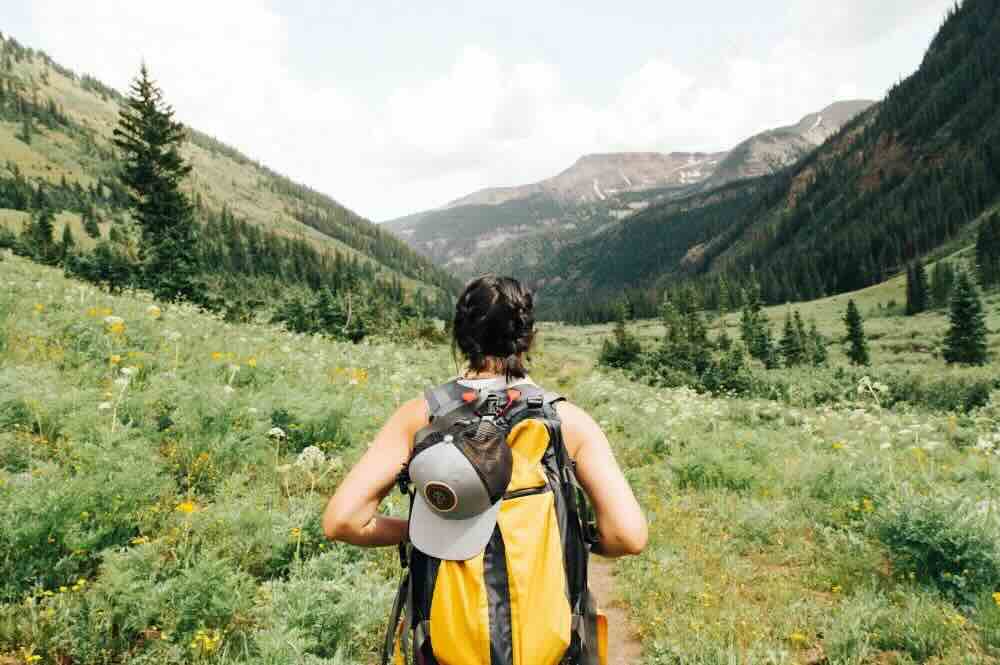 woman with a back pack looking away to some hills