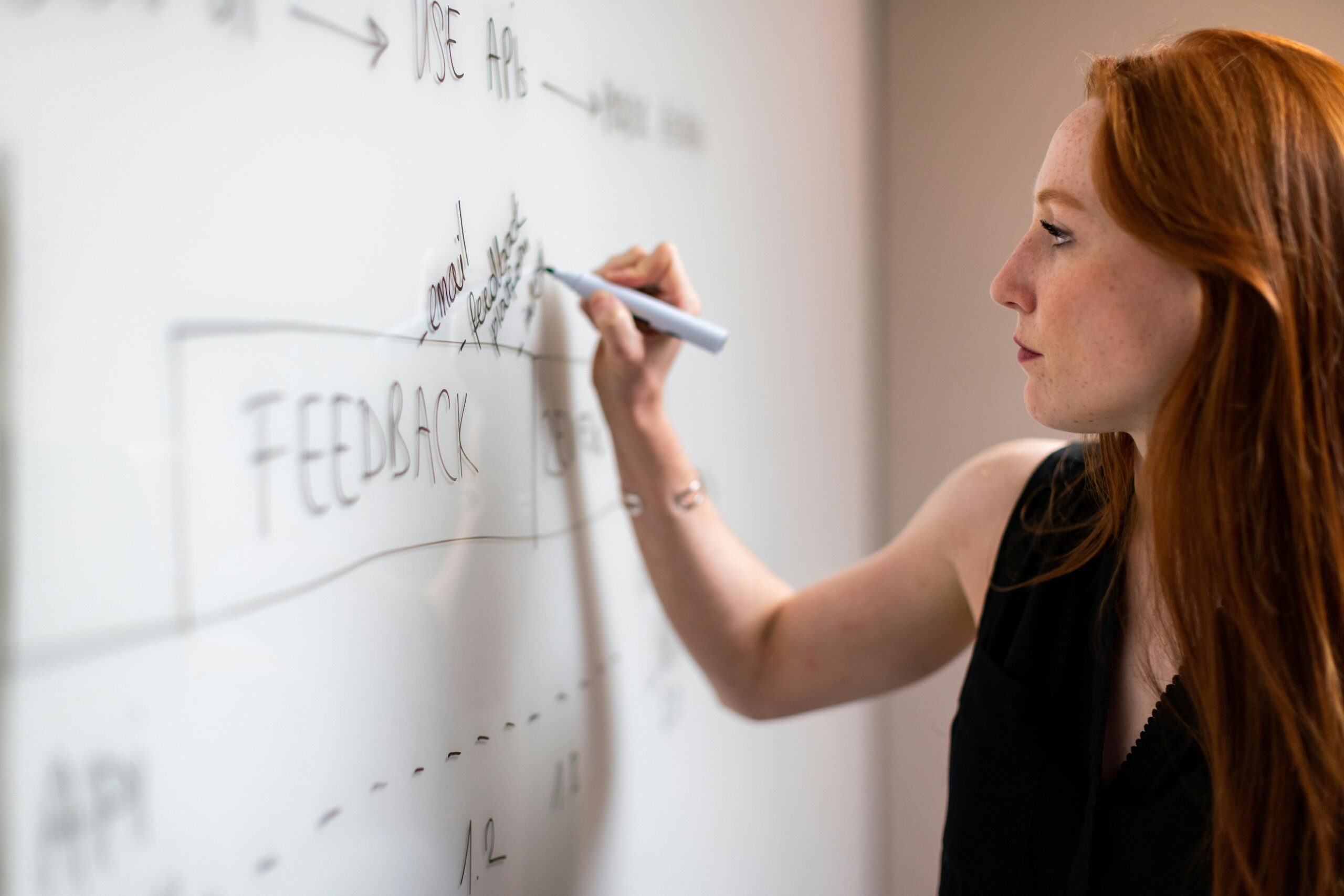Woman writing the work feedback on a white board.