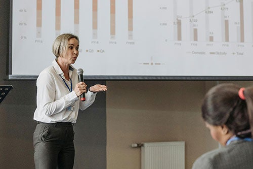 adult female presenting to a room of conference attendees