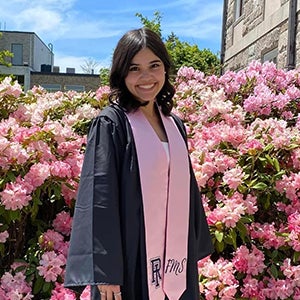 TMd student standing in front of pink flowers