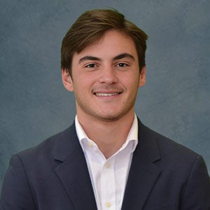 URI student smiling wearing a blue jacket and white shirt