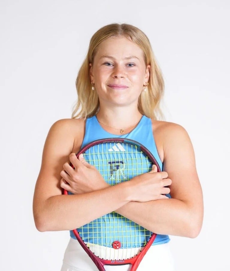 A URI business student holding a tennis racket, smiling.