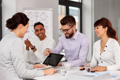 People sitting at a table looking at a screen