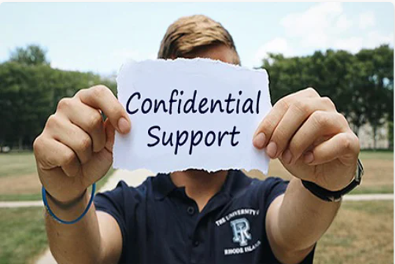 student holding a paper sign that says confidential support