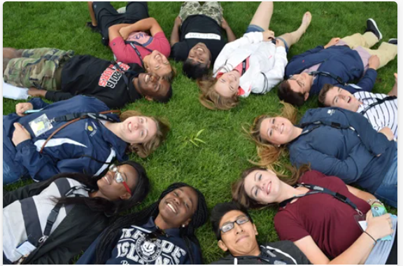 students laying on the ground in a circle