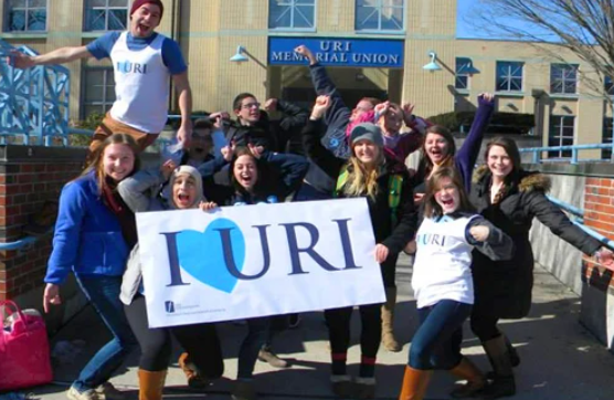 group of students holding a I love URI home