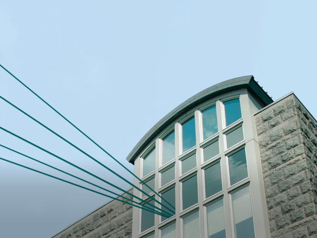 image of Ballentine Hall on the URI campus with lines from the windows to the sky