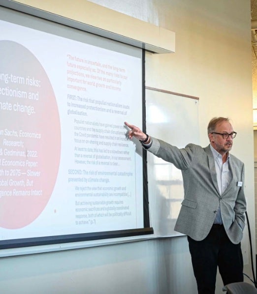 URI faculty member standing at the side of a presentation screen