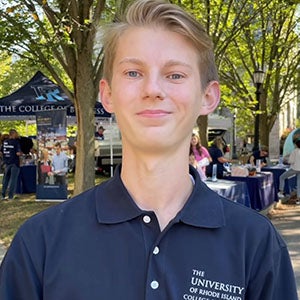 URI student smiling , standing in front of trees