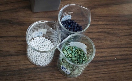 glass beakers filled with raw materials to make fabric
