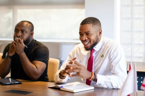 two professionals sit in on a class