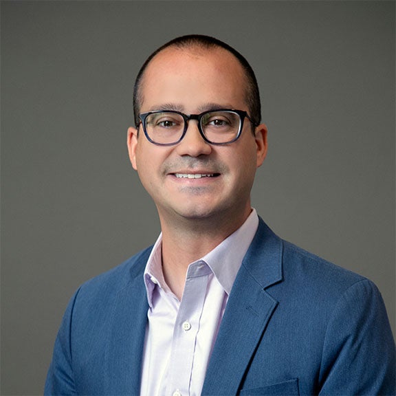 URI PhD student wearing glasses and smiling