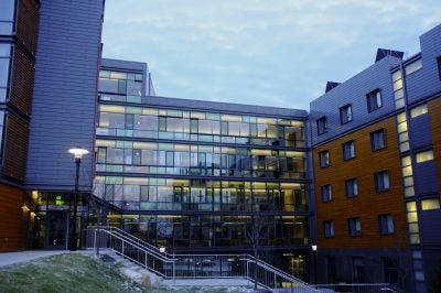 An evening view outside a large Learning Commons building on URI's Kingston campus