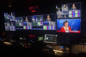 inside a broadcast studio with many digital screens