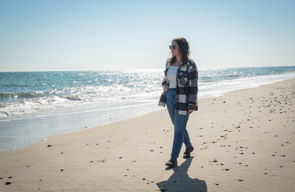 Erica Meier, a Rhode Island Sea Grant-University of Rhode Island Masters of Environmental Science and Management Communications fellow, walks South Kingstown Town Beach.