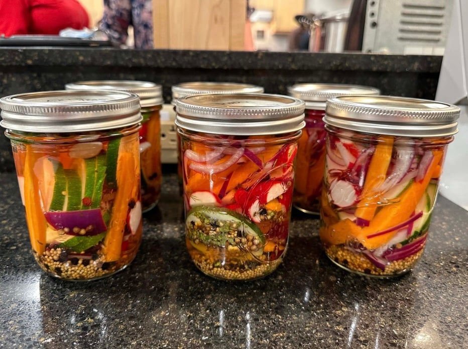 image of six mason jars fulled of colorful pickled vegetables