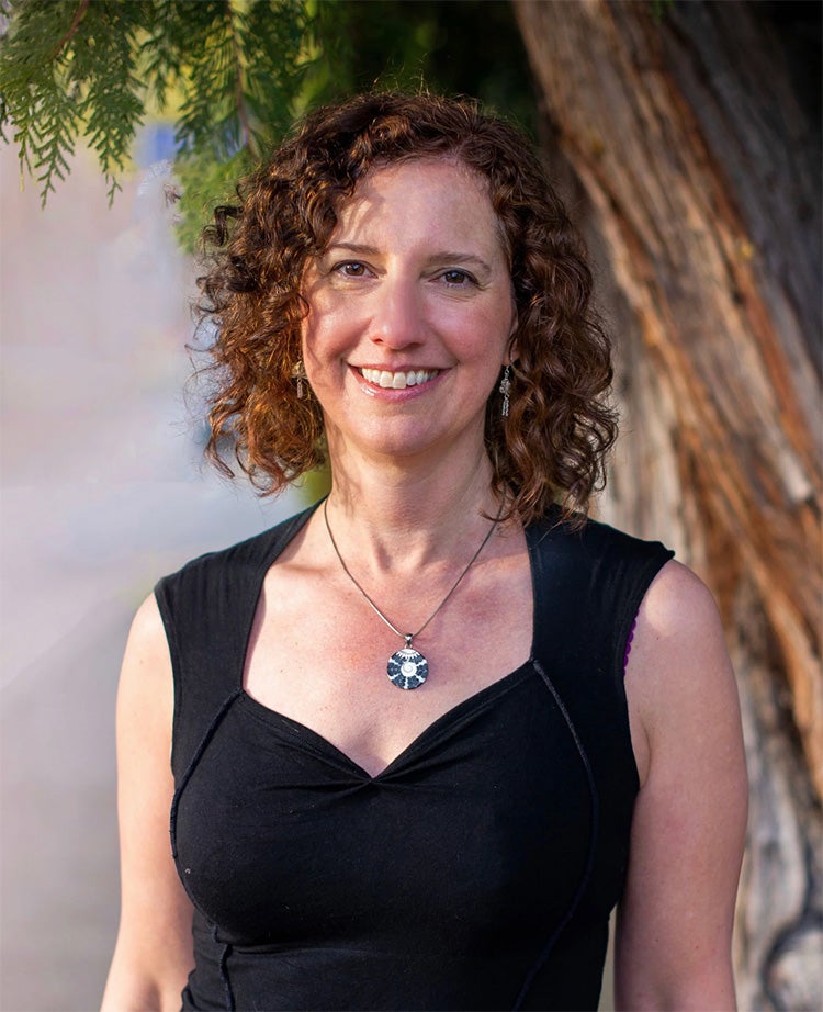 image of journalist Erica Geis wearing a black shirt, smiling directly at the camera.