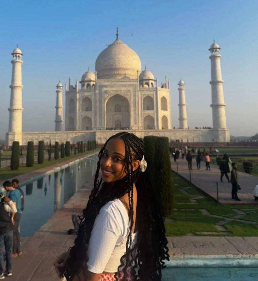 image of URI student posing in front of the Taj Mahal, smiling