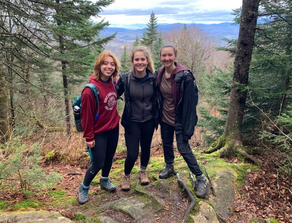 image of three students posing while on a hike in the woods