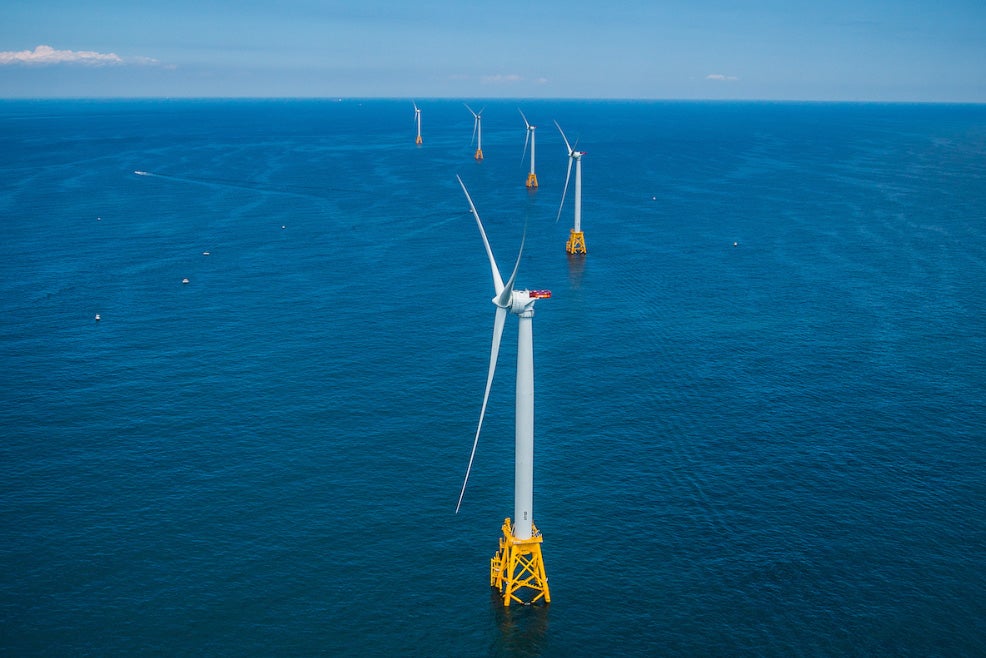 Image of offshore wind turbines in a row on yellow platforms.