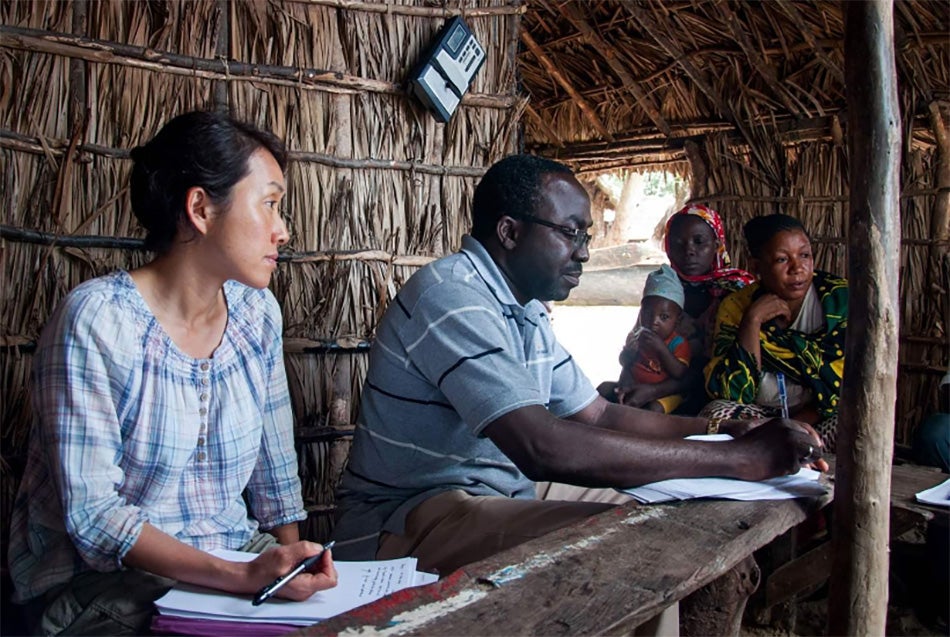 Professor Emi Uchida (left), on an earlier research trip, interviews members of a coastal community in Tanzania about mangrove use.