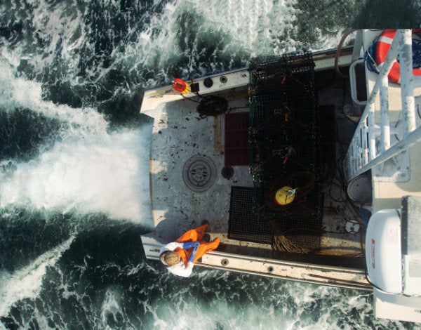 An aerial view of Ebben Howarth ’23 sitting on the side of his lobster boat.