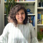 image of CELS assistant professor Melva Treviño Peña smiling in front of a bookshelf