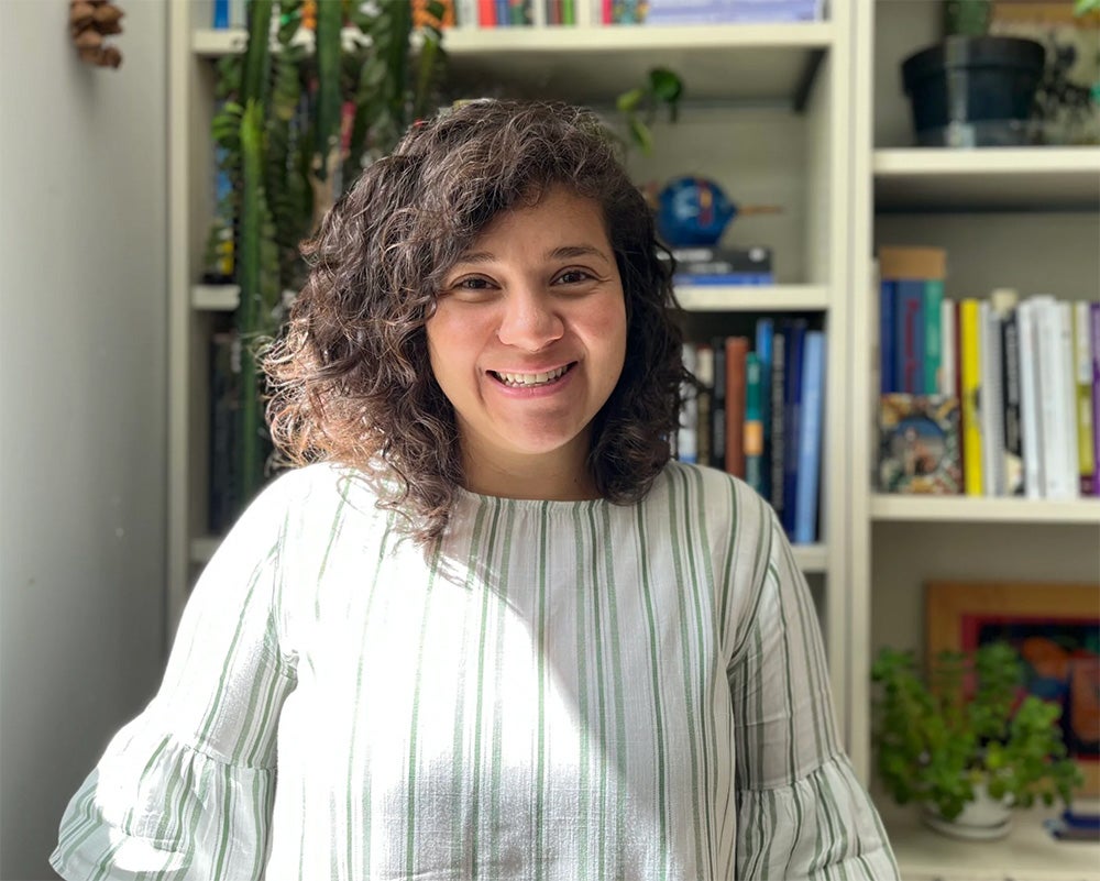 image of CELS assistant professor Melva Treviño Peña smiling in front of a bookshelf