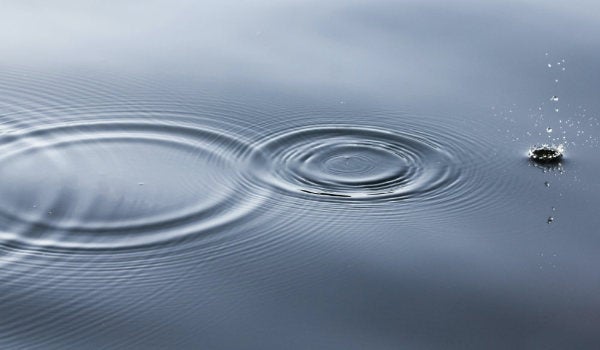 Droplets of water creating a rippling effect on a still surface