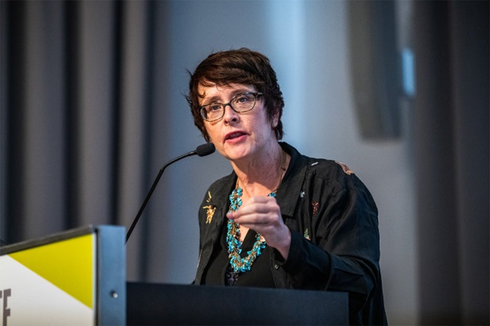 Image of incoming executive director of the Metcalf Institute, Fara Warner, speaking at a podium.