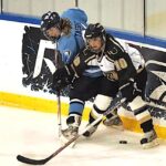 Amanda Tassoni (left) of URI battles for the puck with a player from Lindenwood University. Tassoni earned her bachelor’s and master’s degrees in kinesiology from URI. (Photo by Ryan Prewitt)