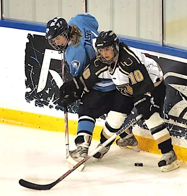 Amanda Tassoni (left) of URI battles for the puck with a player from Lindenwood University. Tassoni earned her bachelor’s and master’s degrees in kinesiology from URI. (Photo by Ryan Prewitt)