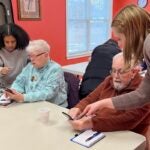 URI students in the Engaging Generations: Cyber-Seniors program help clients navigate through their smart phones. The students work with older adults around the state, helping them take part in the digital world.