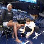 URI alumna Catherine “Dolly” Cairns measures former URI women's basketball team forward Maye Toure's arch before testing her foot biomechanics in the Ryan Center.