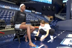 URI alumna Catherine “Dolly” Cairns measures former URI women's basketball team forward Maye Toure's arch before testing her foot biomechanics in the Ryan Center.