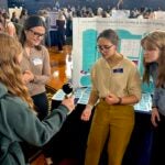 URI students Grace Kimball, Anna Mottola, and Jill Casey test the grip strength of South Kingstown High School students during an interactive health and wellness fair at the high school on Dec. 5.