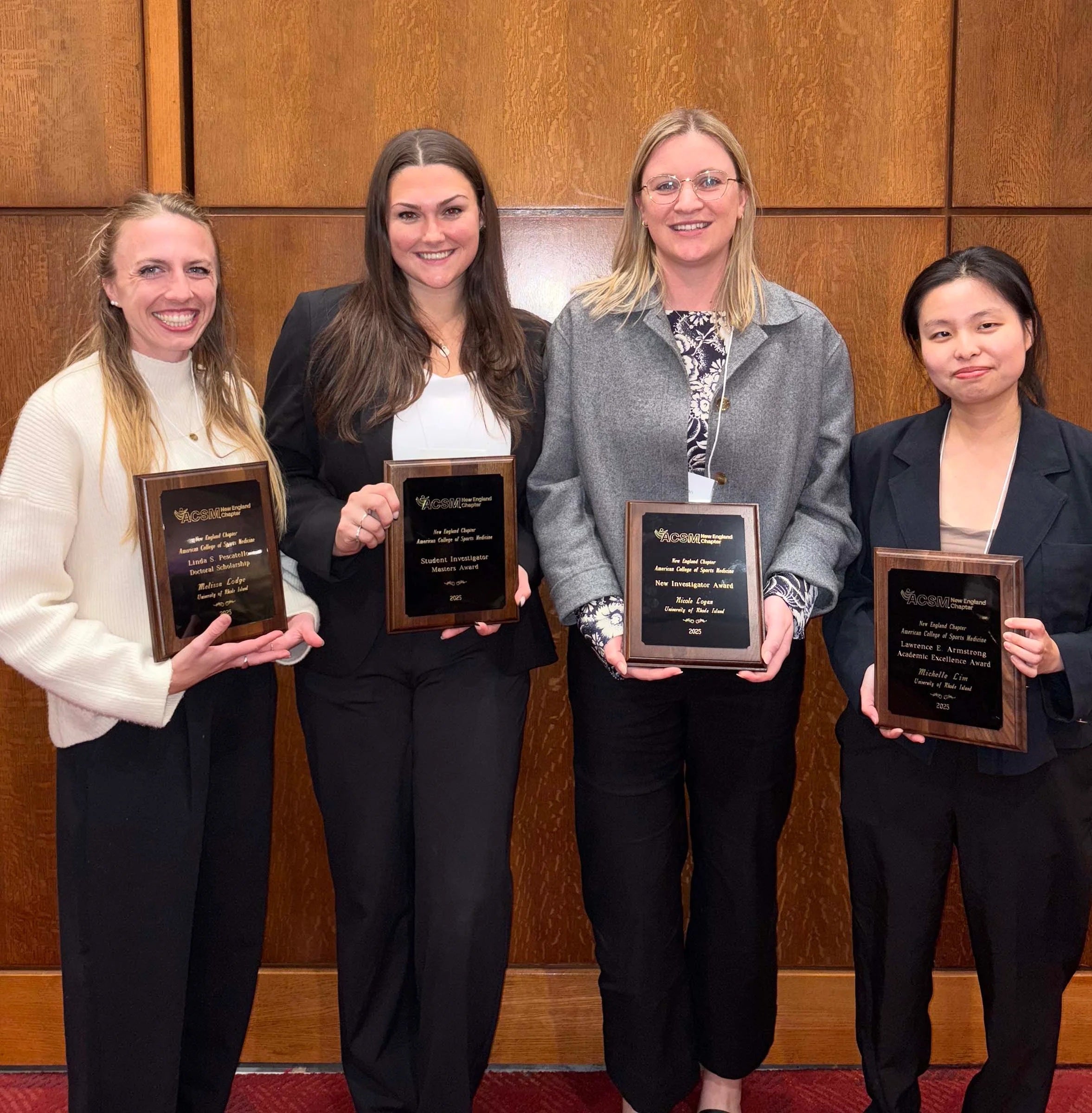 From left, URI kinesiology students Melissa Lodge, Hadley StCyr, Assistant Professor Nicole Logan, and Michelle Lim hold their awards from the New England Chapter of the American College of Sports Medicine fall meeting. (URI photo)