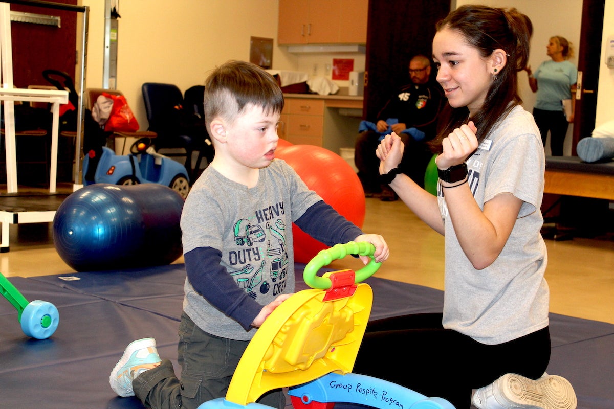 URI Nursing student Emily Nichols works with four-year-old Asher during a respite care program on campus. A new certificate program in Early Intervention will allow childhood care workers like her to be certified, helping relieve the shortage of early intervention professionals.