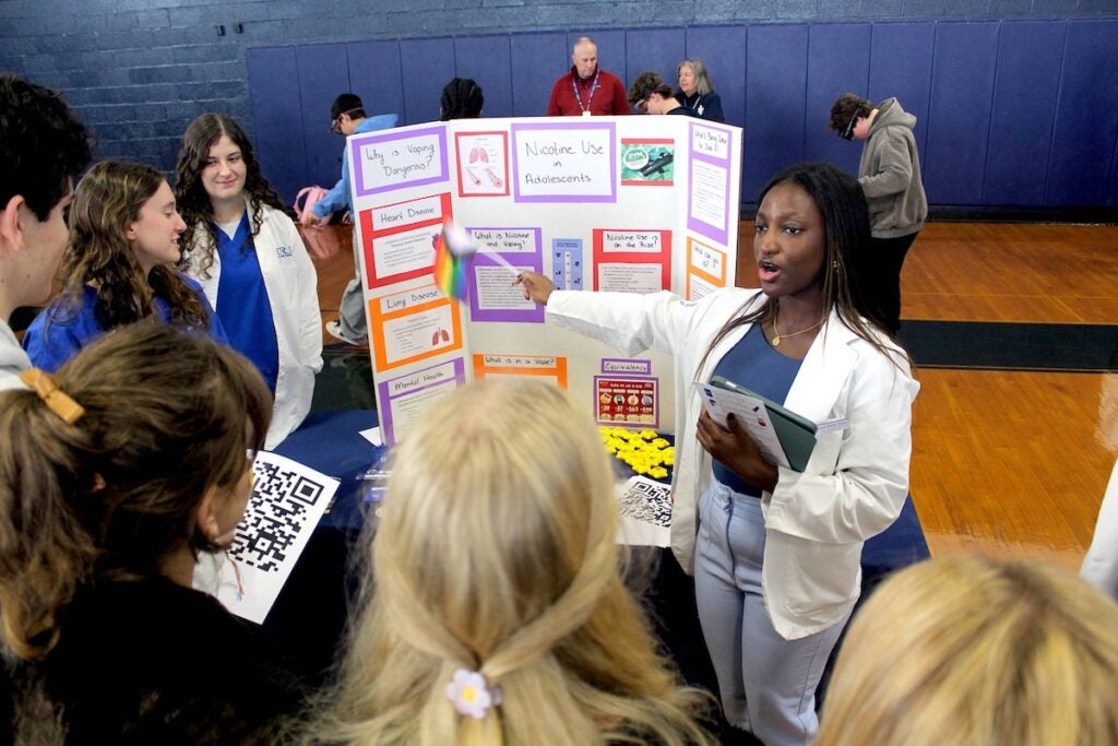 URI pharmacy student Myriam Sarah Thiam explains the dangers of smoking and vaping to South Kingstown High School students during an interprofessional health and wellness fair at the high school Dec. 6.