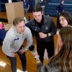 URI students Matt Rajotte, Brendan Stubbs and Mia Ragosta test the grip strength of South Kingstown High School students during an interprofessional health and wellness fair at the high school Dec. 6.