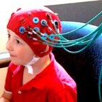 A young study participant wears a functional Near Infrared Spectroscopy system cap, which allows neuro scientists to measure brain activity by monitoring changes in blood flow in the brain.