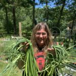 Kate Hardesty holding garlic scapes