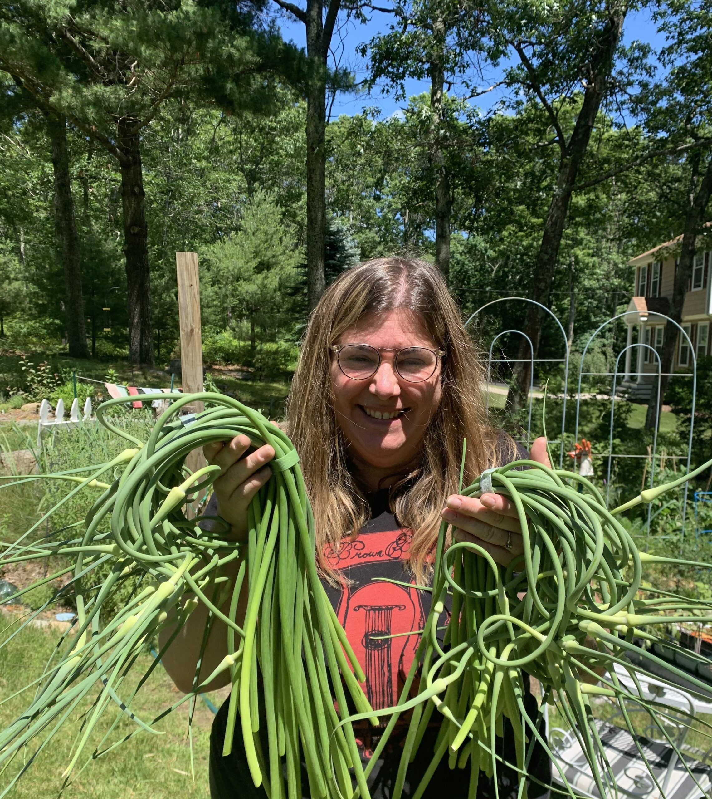 Kate Hardesty holding garlic scapes