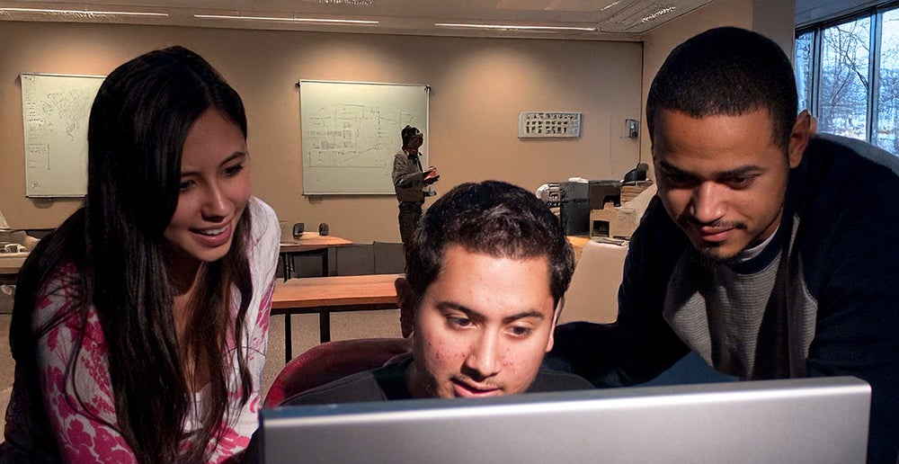STudents collaborate at a computer.