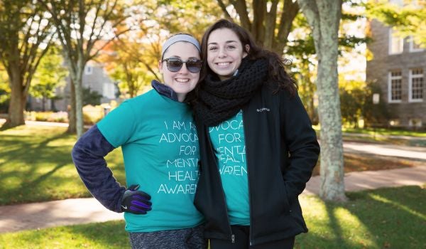 two young women stand together at a resource fair