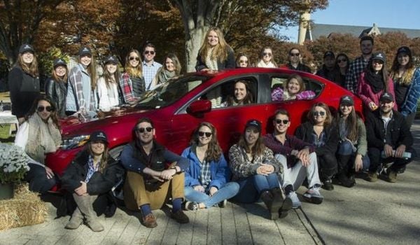 students gathered around a car